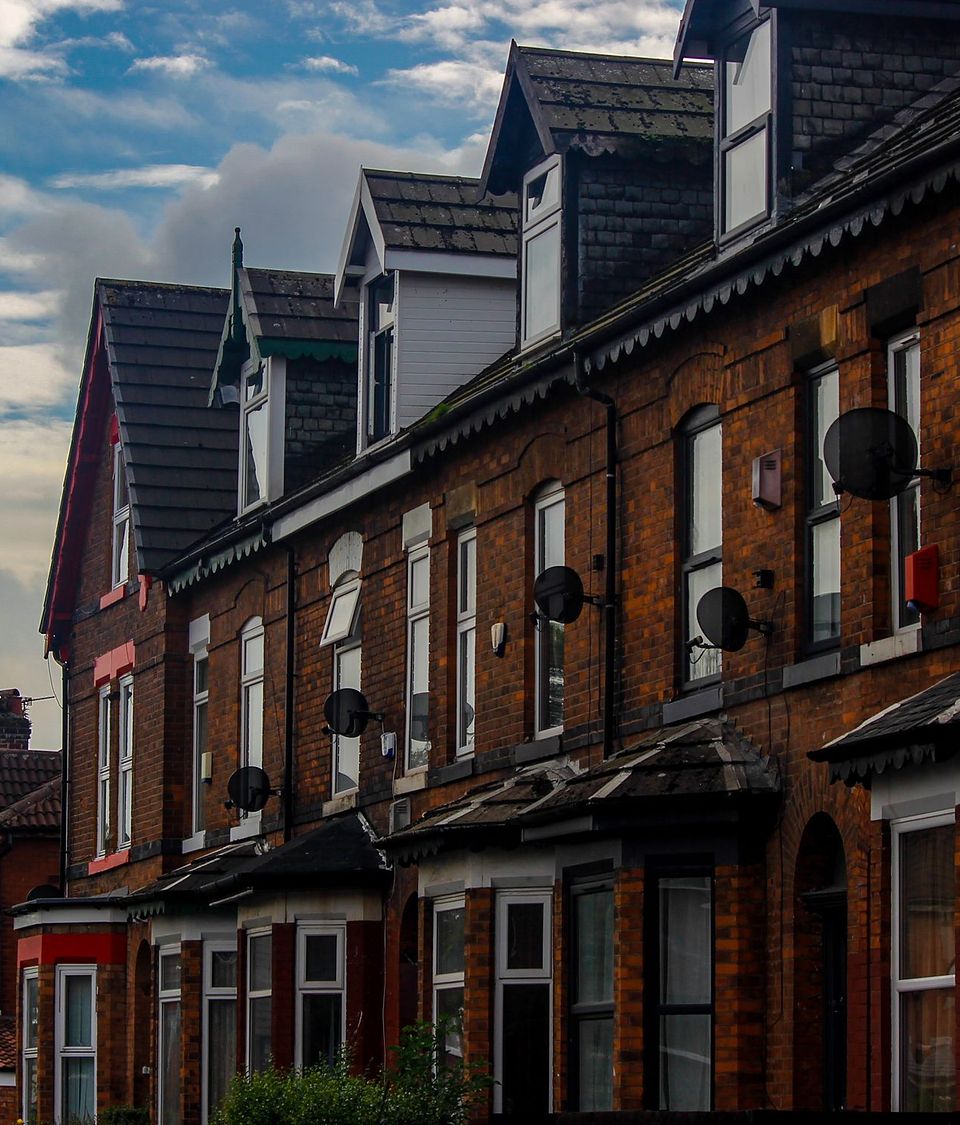 A run of brick terraces with dormer windows and bay fronts